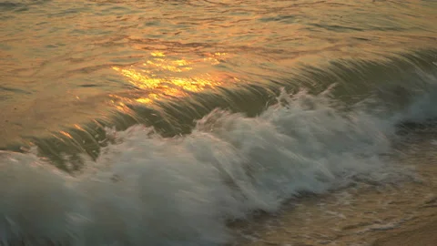 Golden sand with rolling waves at sunset Stock Footage 112952664