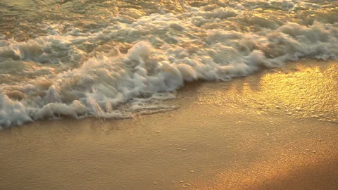 Golden sand with rolling waves at sunset Stock Footage 112953034