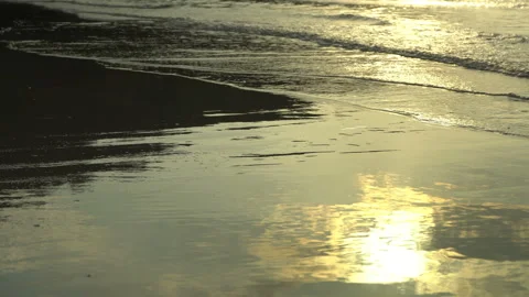 Golden sand with rolling waves at sunset Stock Footage 112953514