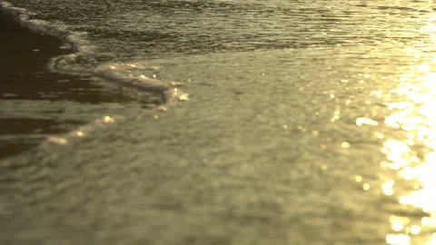 Golden sand with rolling waves at sunset Stock Footage 112953724
