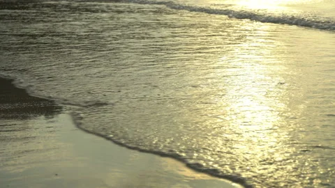 Golden sand with rolling waves at sunset Stock Footage 112953933
