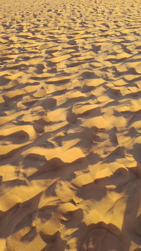 Golden sand texture background with footprints and sunset shadows. 스톡 동영상 312898105