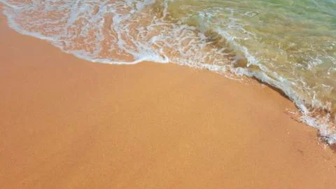 Golden sand washes the warm sea on a Sunny day. Stock Photos
