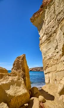 Golden Sandstone Cliffs and Azure Sea at Playa Amarilla, Mazarron, Spain Stock Photos