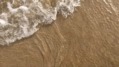 Golden sandy beach wave creating water ripples in high tied Stock Footage 341466236