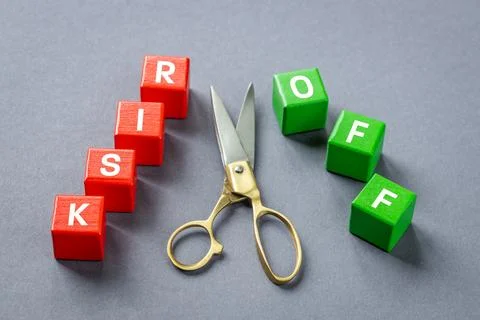 Golden scissors separating word RISK on red blocks from word OFF on green  Foto stock
