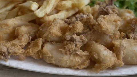 Golden seafood highlights crispy texture and appetizing presentation. Calamari Video stock 332874840
