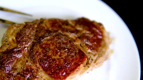 Golden seared beef steak served on white plate with crispy crust and juicy Stock Footage 346184408