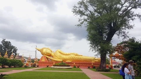 Golden sleeping Buddha statue and tourists, Pha That Luang, Vientiane, Laos Vídeos de archivo 75002811