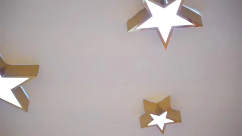 Golden Star Ceiling Lights Glow in Soft White Against Smooth Surface Video stock 320223796
