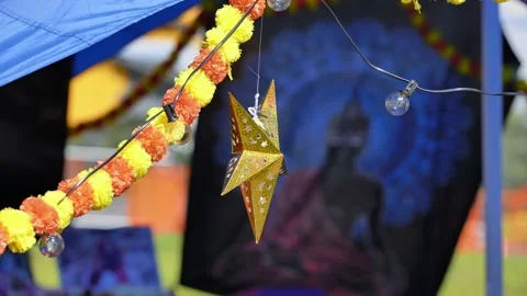 Golden star hanging with string lights and flower garland decorating outdoor Video stock 316179379