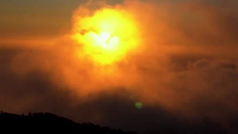 Golden Sun Breaking Through Clouds Over Silhouetted Landscape. Stock Footage 323761709