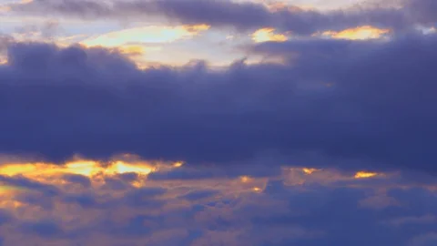 Golden sun breaking through dark blue fluffy quickly passing clouds 4K Timelapse Stock Footage 106017308