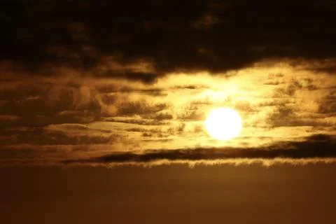 Golden sun breaking through dramatic storm clouds at sunset 스톡 사진