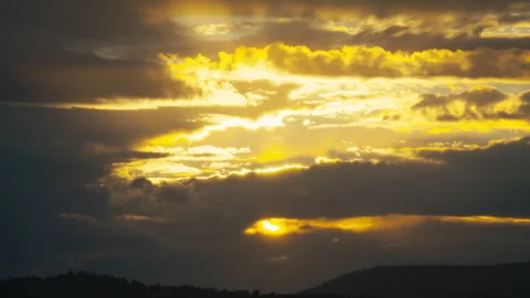 Golden Sun Breaking Through Thick Storm Clouds at Sunset Stock Footage 344088085