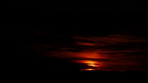 Golden sun completely set over the horizon in the dark red evening cloudy sky 動画素材 124180816