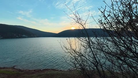 Golden sun dips behind distant hills . Bovan Lake Vidéo 330989288