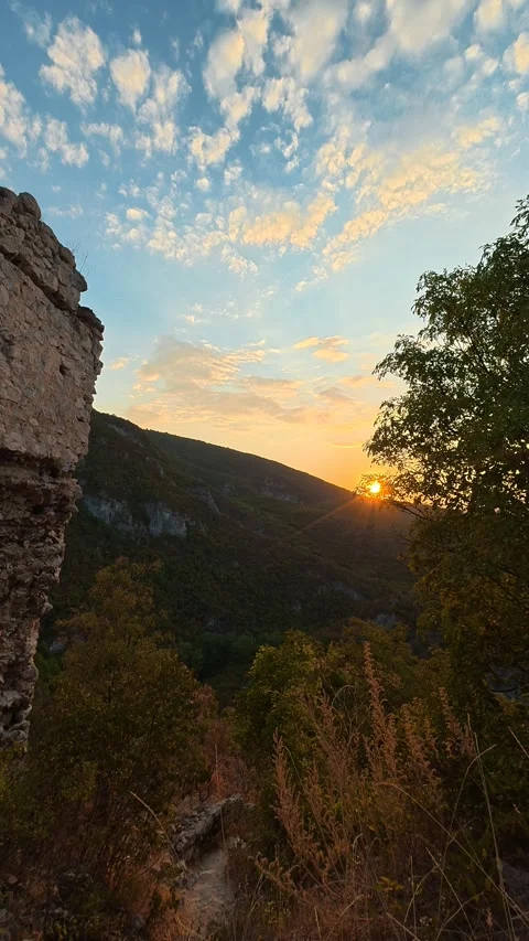 Golden sun dips behind distant hills. Soko Grad, Vertical 動画素材 345898024