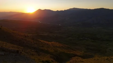 Golden sun dips behind rugged mountains 스톡 동영상 332573121