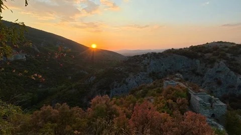 Golden sun dips behind rugged cliffs. Soko Grad, Serbia 動画素材 345897248