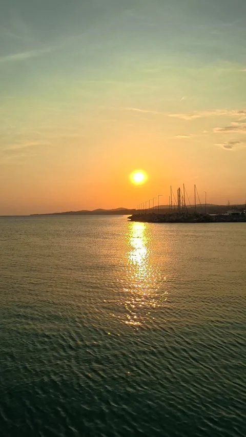 Golden sun dips low over calm waters. Nikiti, Greece. Vertical Stock Footage 338357628