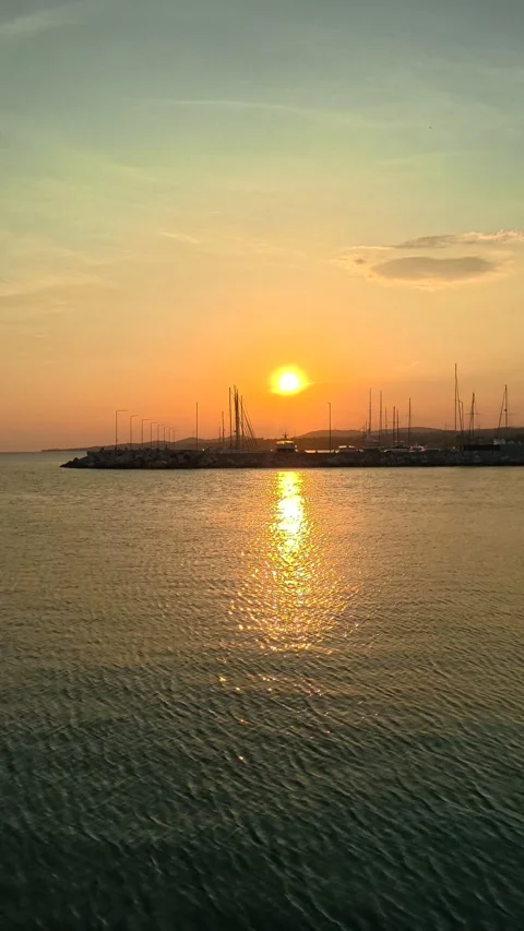 Golden sun dips low over calm waters. Nikiti, Greece. Vertical Stock-Footage 338357632
