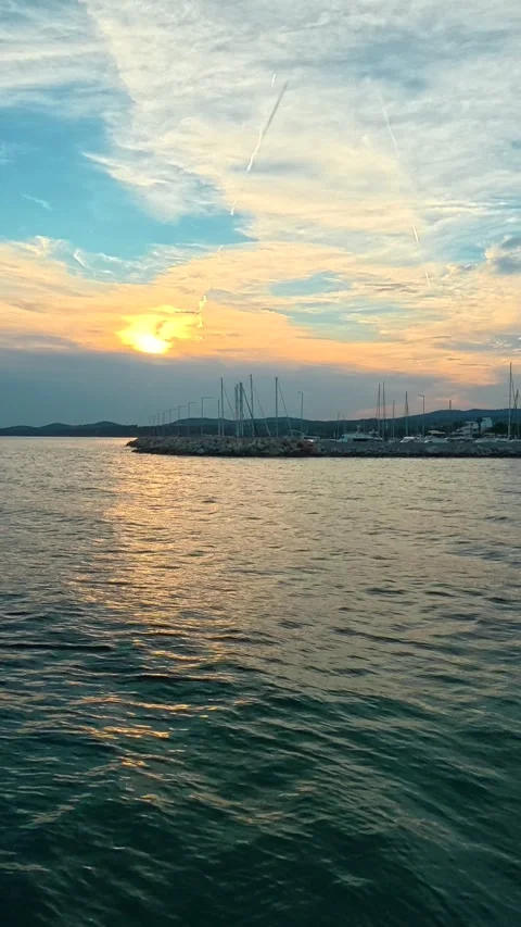 Golden sun dips low over calm sea waters. Nikiti, Greece. Vertical Stock-Footage 339628629