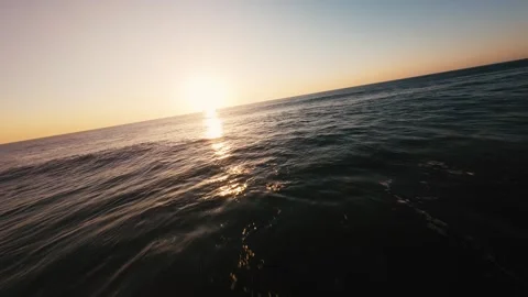 Golden sun dips low over calm, foamy waves Stock Footage 339788961