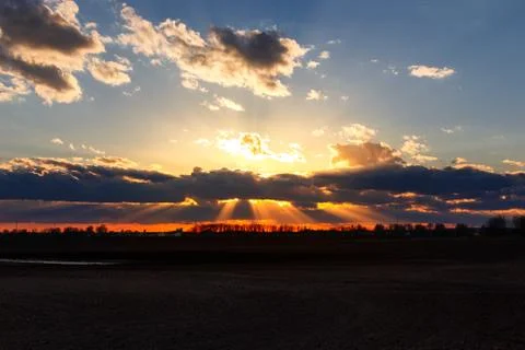 Golden Sun rays behind clouds sunset Stock Photos