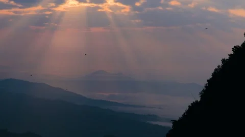 Golden sun rays pierce through early morning clouds, casting dramatic beams.. Stock Footage 311885807