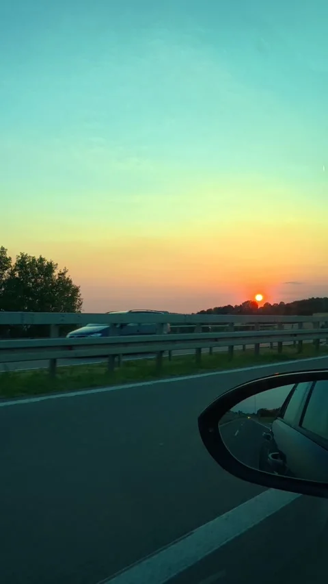 Golden sun sets behind highway barrier. Vertical Vídeo Stock 341968344