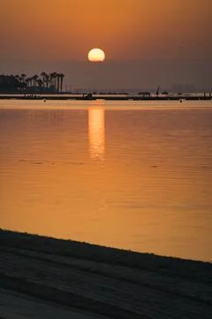 Golden sun sets over calm water Stock Photos