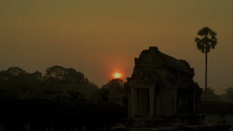 Golden sun setting behind Angkor Wat ancient temple ruins Vídeo Stock 331957561