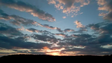 Golden sun setting behind a hill with cloudy sky 库存影片 334451372