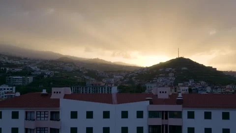 Golden sun setting behind a hillside town Видео 333695027