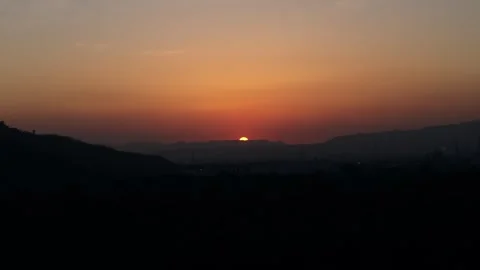 Golden sun setting behind a mountain silhouette Vidéo 341076930