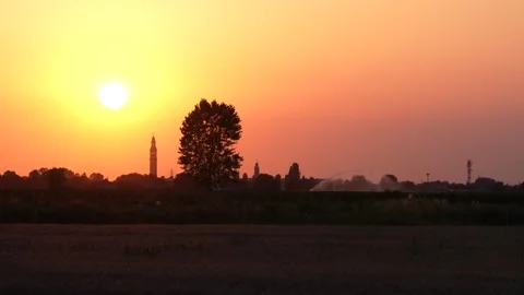 Golden sun setting behind a silhouetted italian countryside Stock Footage 345828208