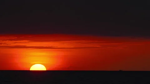 Golden sun setting below sea horizon during dramatic red sunset Stock Footage 342346714