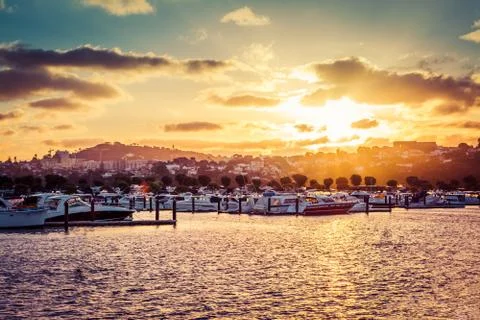 Golden sun setting into clouds over marina Stock Photos