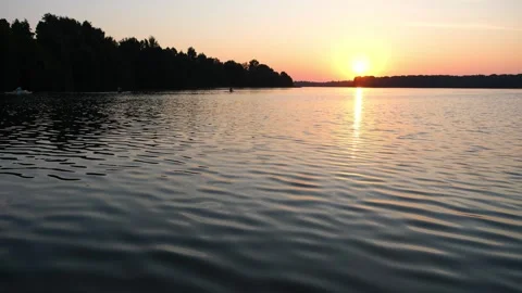 Golden sun setting over a calm forest lake. Scenic landscape showing the Vidéo 340356239