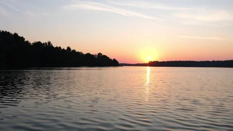 Golden sun setting over a calm lake. Peaceful nature landscape with horizon line Vidéo 340356533