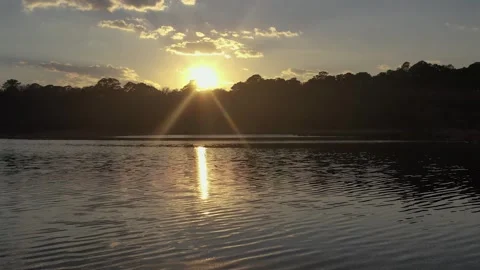 Golden sun setting over forest lake and calm water Stock Footage 153800728