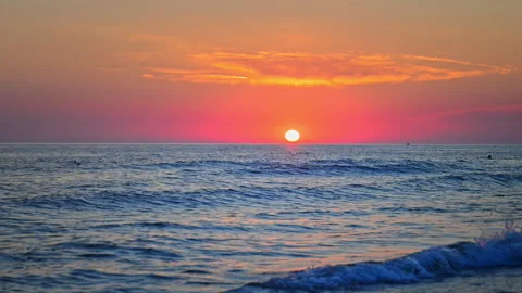 Golden sun setting over ocean horizon with gentle waves and vibrant sky Stock Footage 335421994