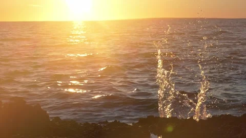 Golden sun setting over the ocean with a dynamic water splash Stock Footage 337418516