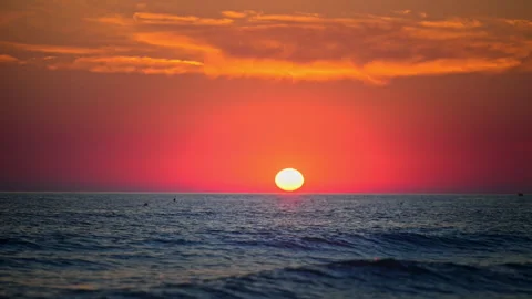 Golden sun setting over peaceful ocean horizon with vibrant evening sky Stock Footage 335422057