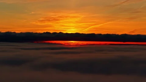 Golden sun setting over thick cloud blanket aerial wide shot mindfulness Stockbeeldmateriaal 333427505