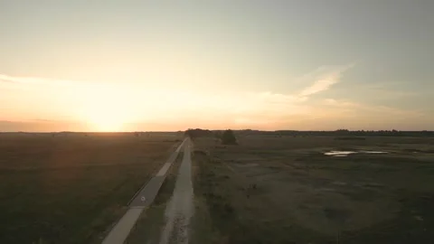 Golden sun setting over a tranquil, empty countryside road Stock-Footage 293158910