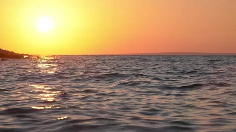 Golden sun setting over tranquil ocean waves during late evening Stock Footage 337409602