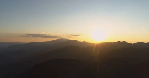 Golden sun shining over dark mountain peaks Stock Footage 129397138