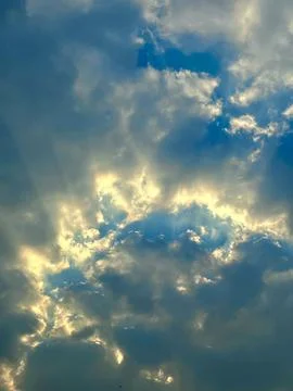 Golden Sunbeams Breaking Through Dramatic Clouds in a Scenic Blue Sky View Stock Photos